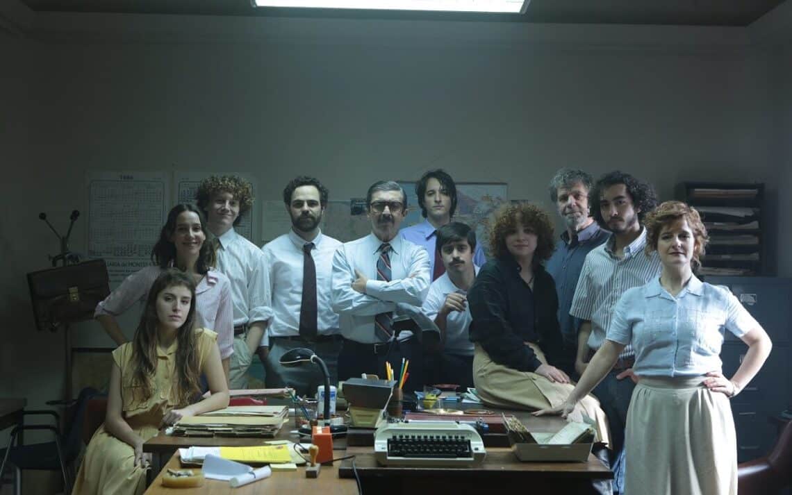 Frame do filme Argentina, 1985, com vários personagens que trabalharam recolhendo provas contra os ditadores de pé, em torno de uma mesa cheia de papéis de processos jurídicos