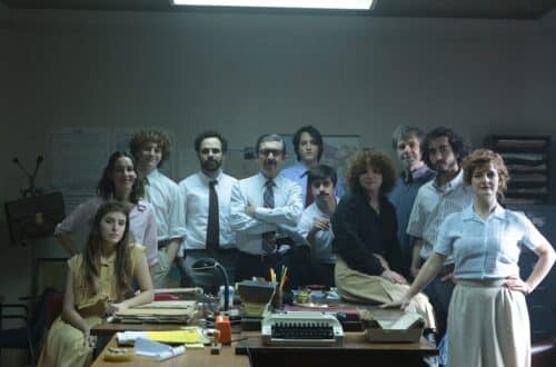 Frame do filme Argentina, 1985, com vários personagens que trabalharam recolhendo provas contra os ditadores de pé, em torno de uma mesa cheia de papéis de processos jurídicos